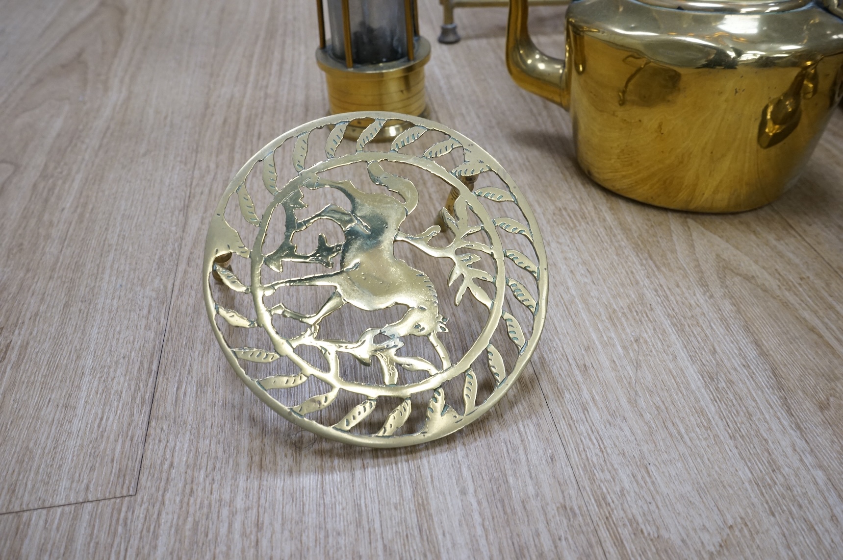 A fire brass guard, pair of candlesticks, kettle, miner's lamp etc, fire guard 54cm high.